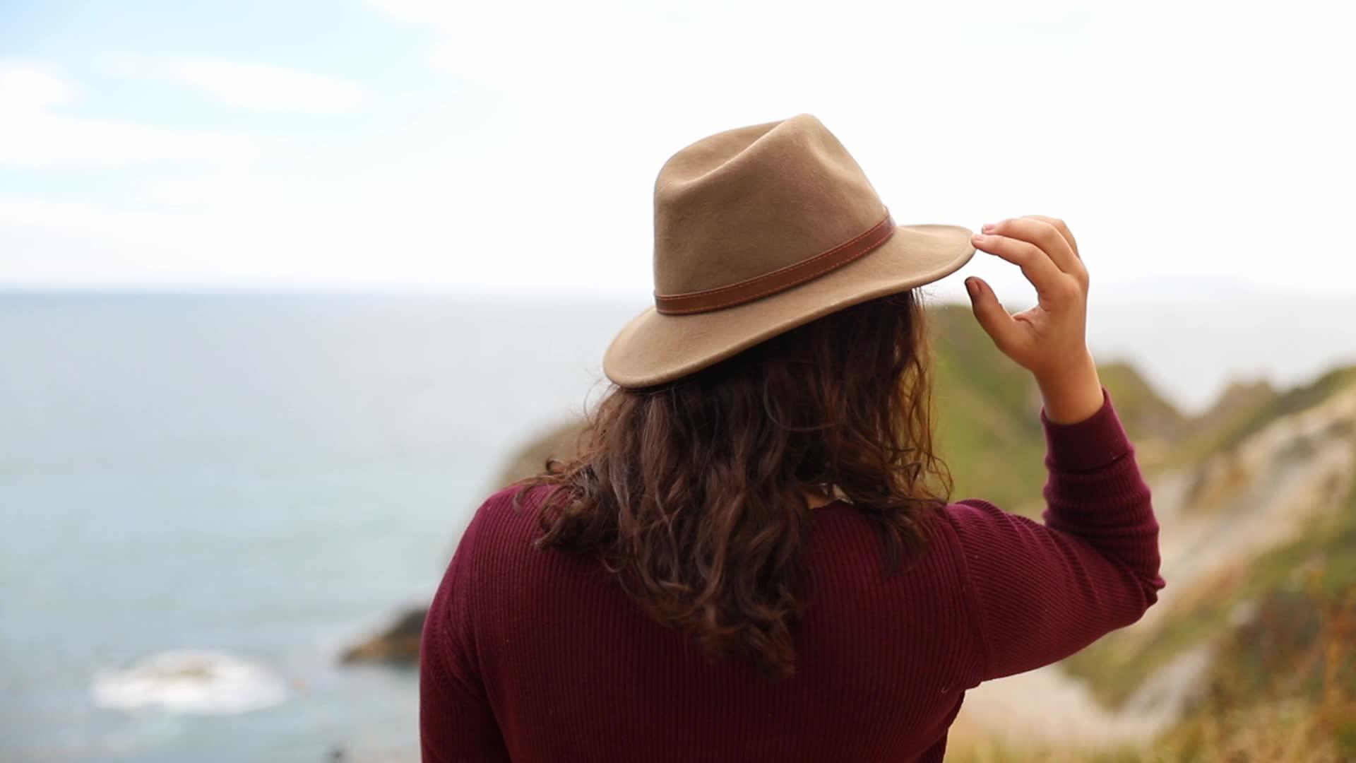 女性在风中享受极地海岸风景视频的预览图