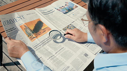 老人用放大镜看报纸视频的预览图
