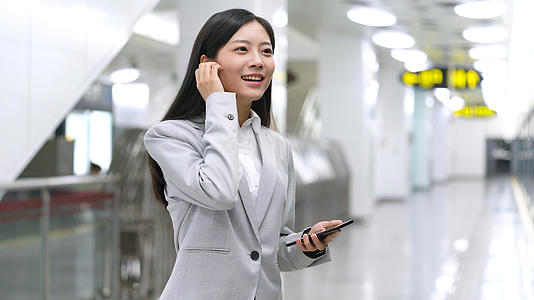 4k商务女性在地铁站接电话打电话视频的预览图
