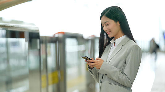 4k在地铁站内使用手机等待地铁的女性白领视频的预览图