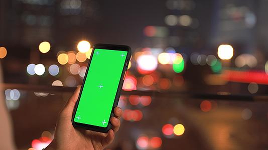 4K夜晚车流灯光背景下点击手机绿幕视频的预览图