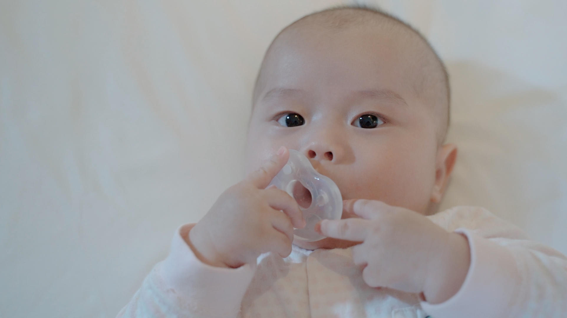 4k婴儿宝宝在床上开心的吃奶嘴视频的预览图