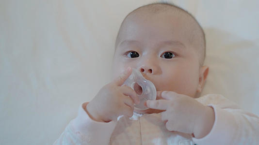 4k婴儿宝宝在床上开心的吃奶嘴视频的预览图