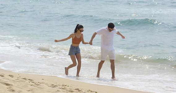 8K情侣手牵手在沙滩上开心散步视频的预览图