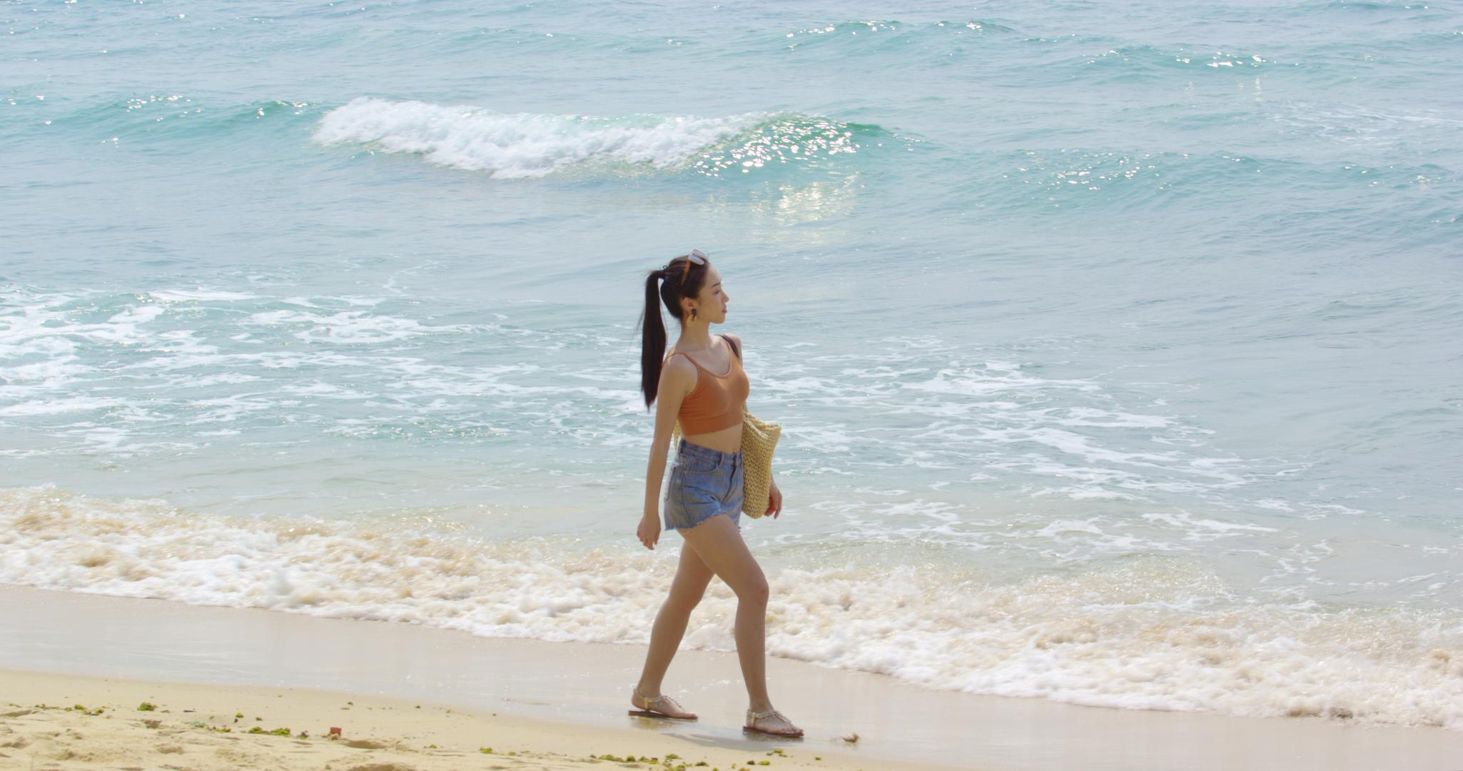 8K年轻女性在沙滩上散步视频的预览图