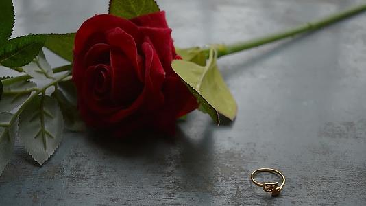关闭简单的金属地板上的金色订婚戒指首饰柔软的焦点浪漫的红色视频的预览图