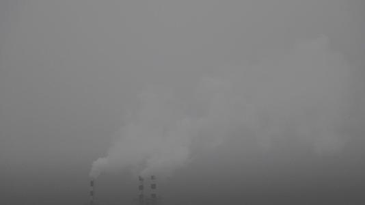 烟雾从锅炉房的烟囱里冒出来在雾蒙蒙的冬天视频的预览图