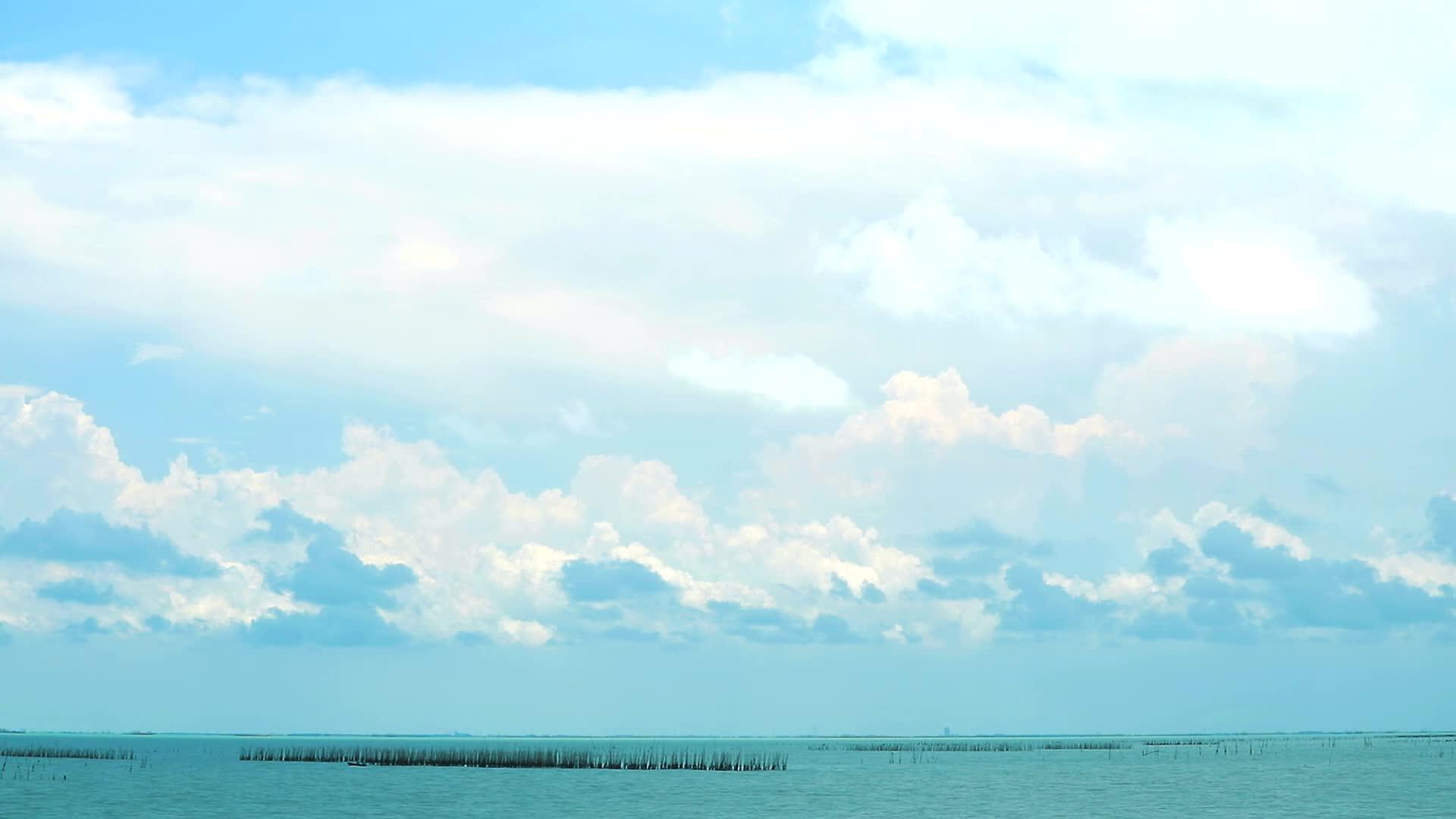 白云和灰云在海上移动穿过牡蛎养殖场视频的预览图