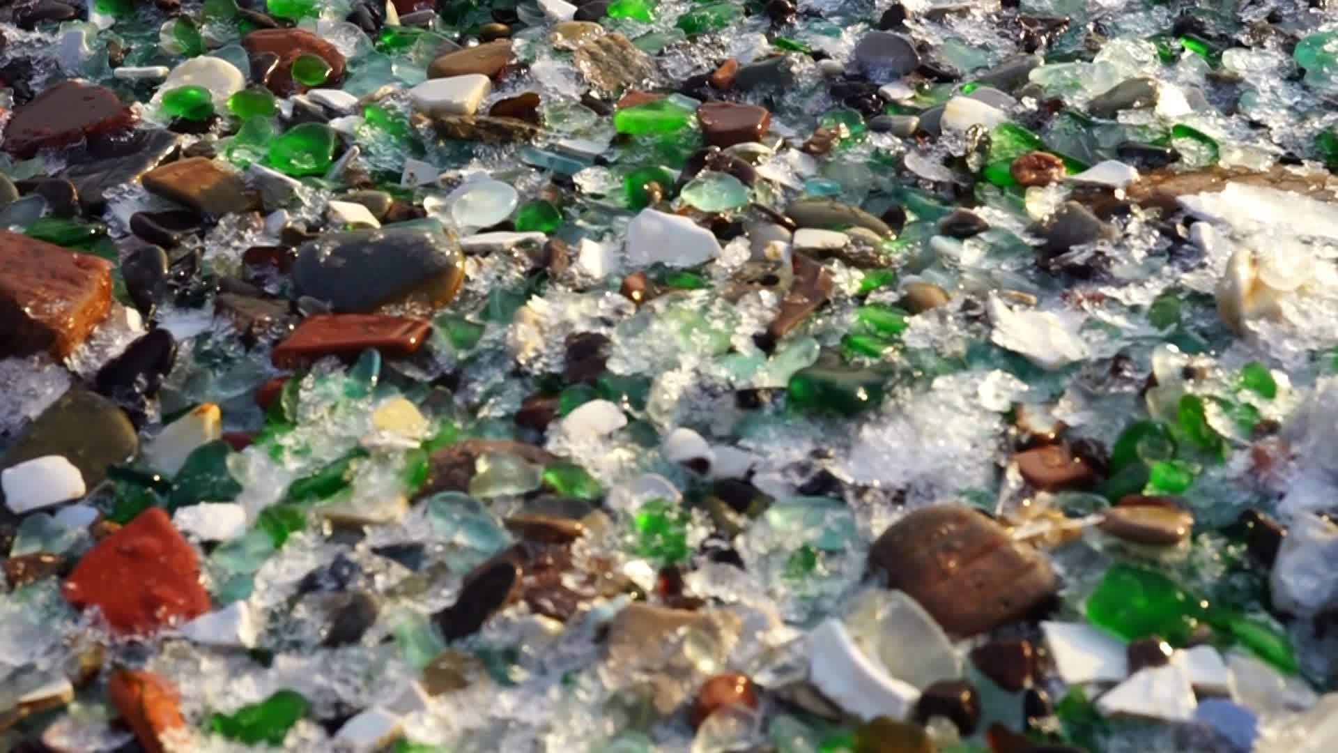 海滩上彩色海玻璃的背景视频的预览图