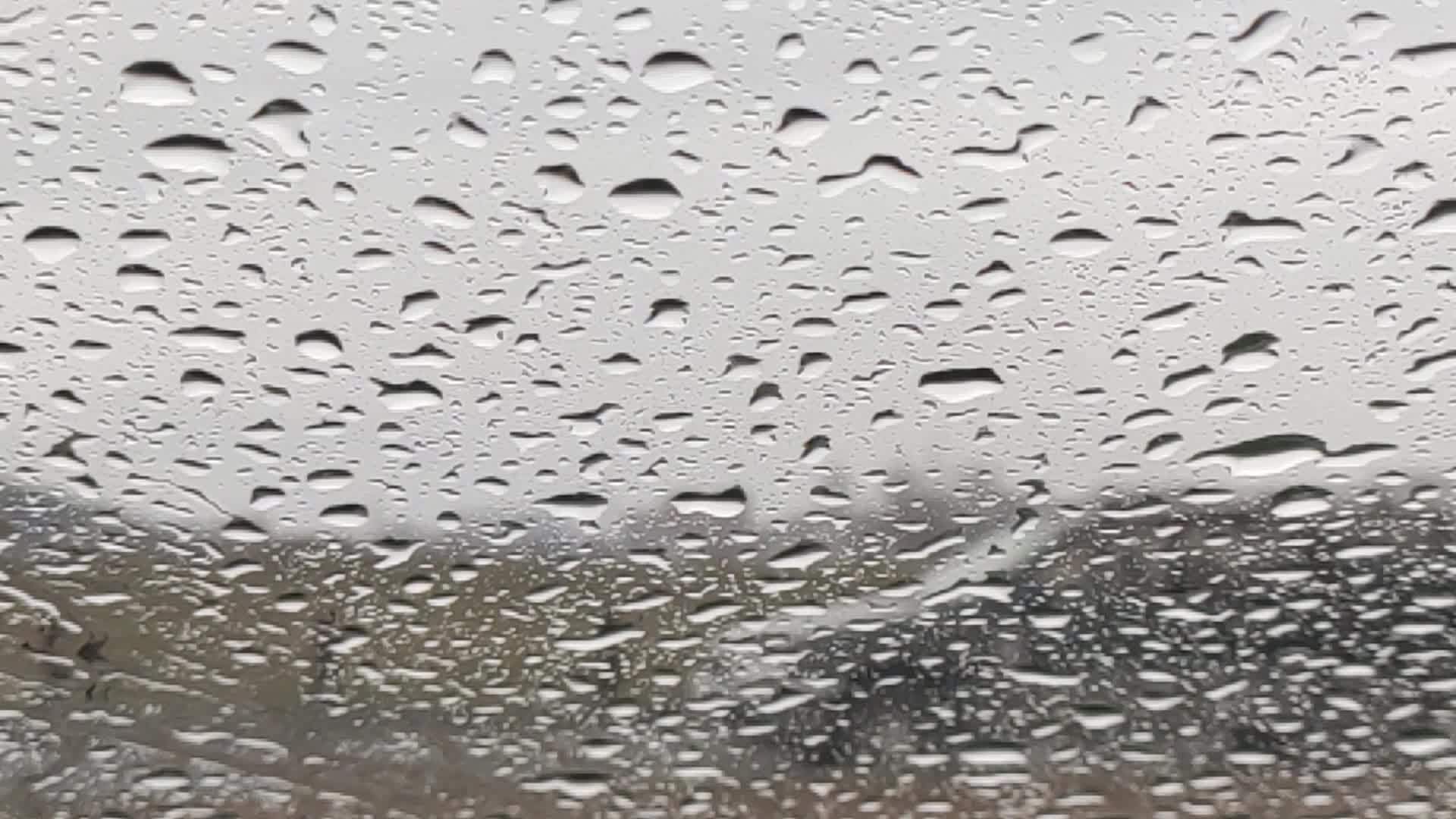 玻璃上有雨滴的自然背景视频的预览图