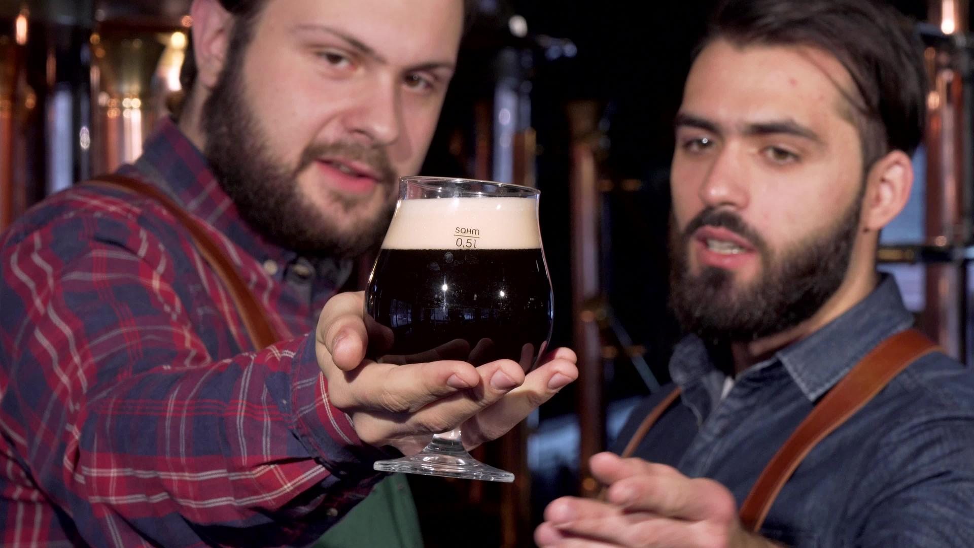 选择性地关注酒商手中的一杯黑啤酒视频的预览图