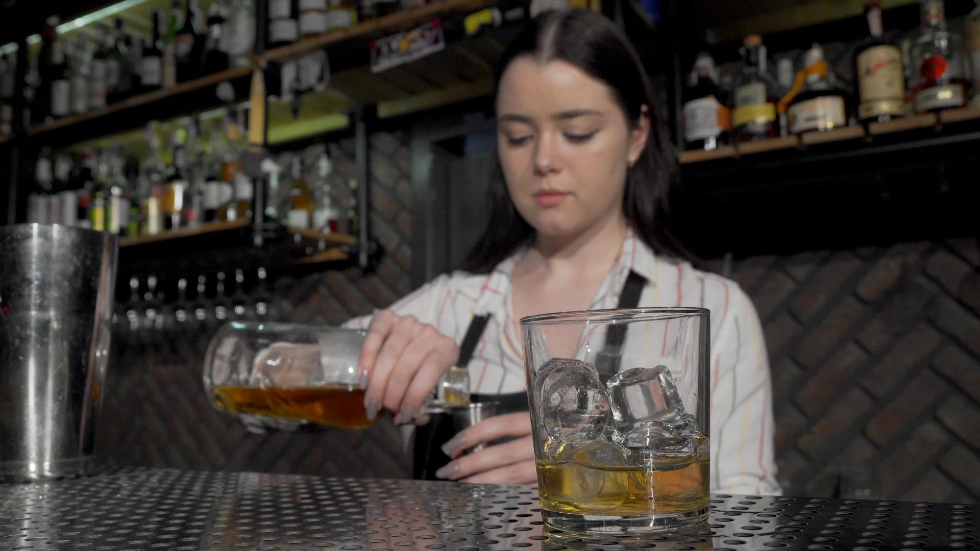 在酒吧工作时做鸡尾酒的女性酒保视频的预览图