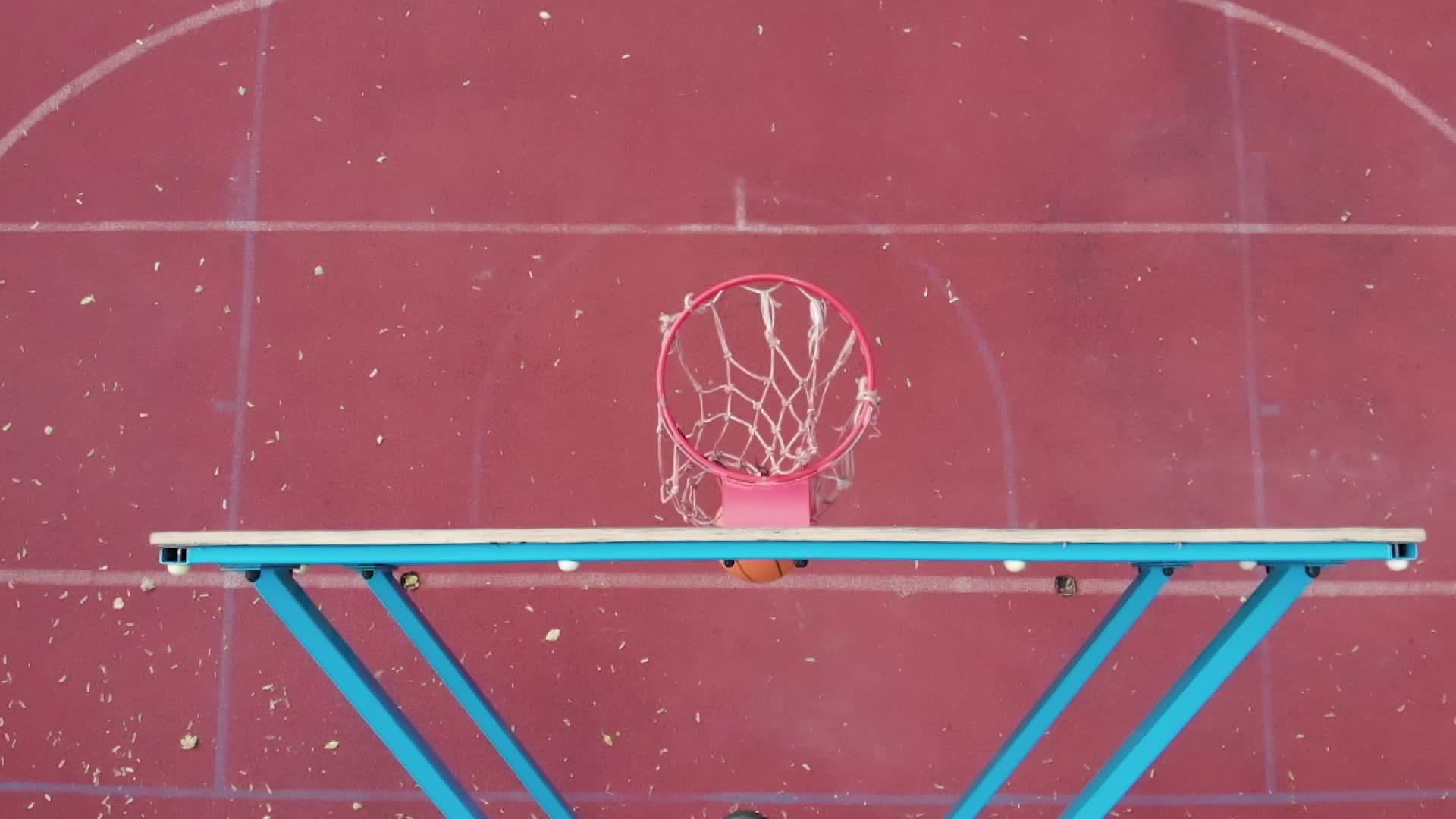 将橙色篮球从篮球后板上方的顶角向上倾斜用慢动作打篮子视频的预览图