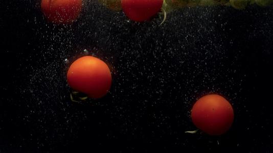 鲜贝芽和番茄在水中落下并喷洒视频的预览图