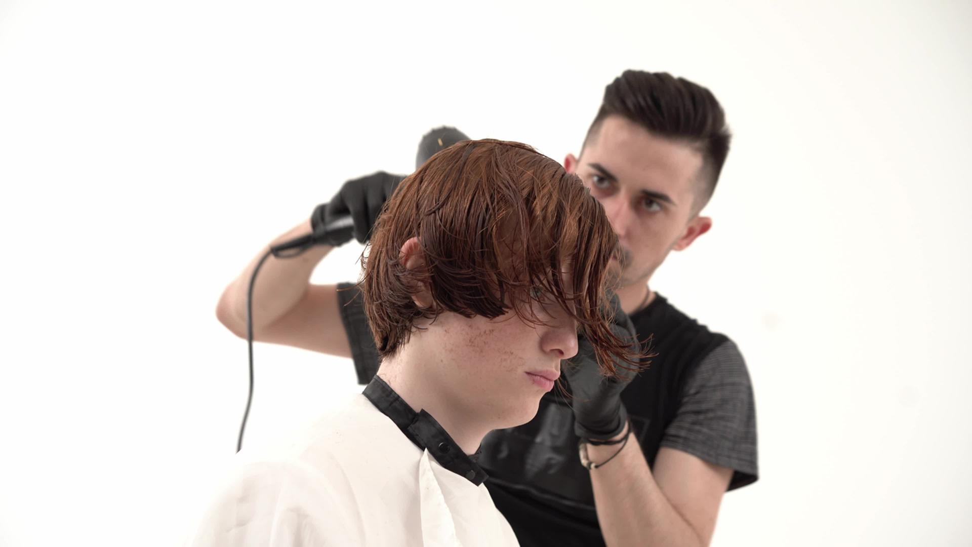 理发师用吹发机烘干客户的头发视频的预览图