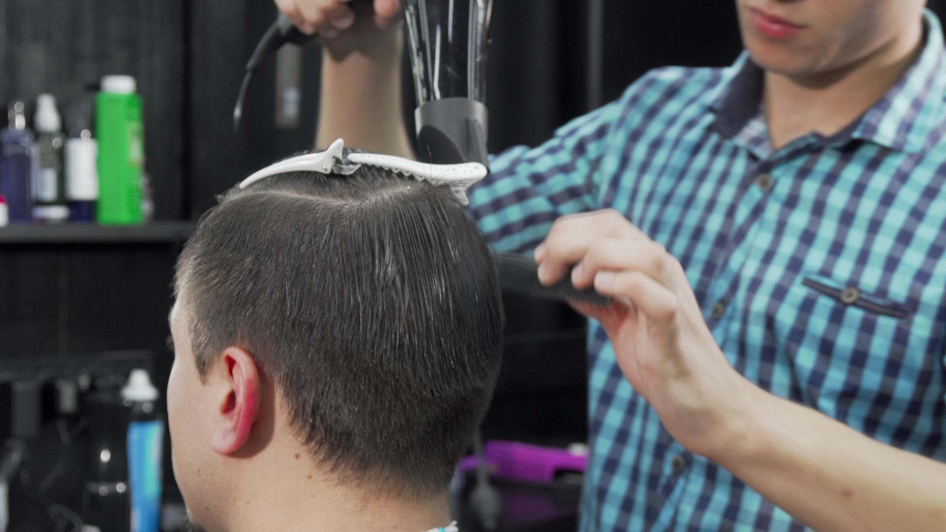 一个不知名的男人被理发师擦干了头发视频的预览图