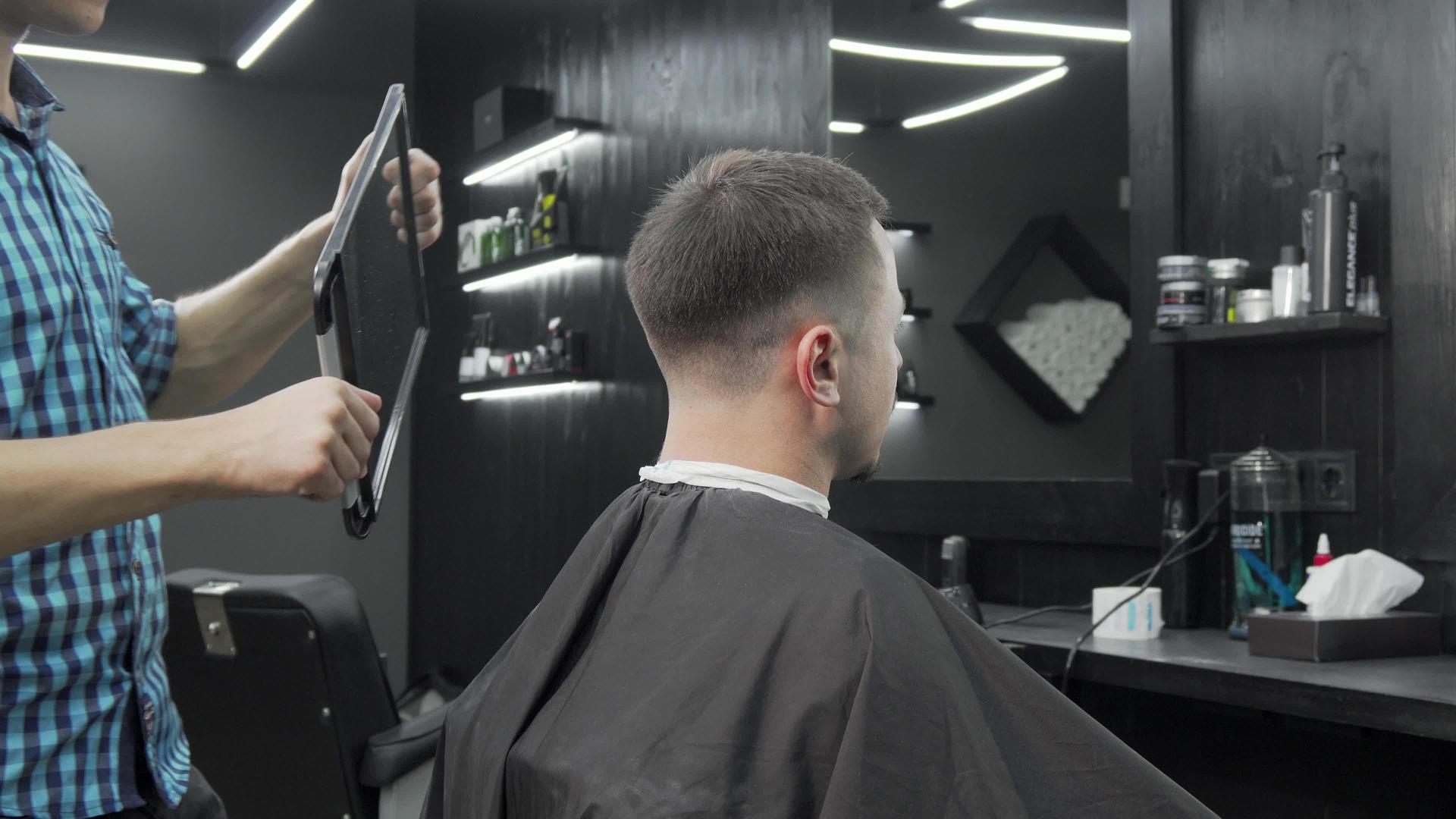 理发师拿着镜子让男顾客检查新发型视频的预览图