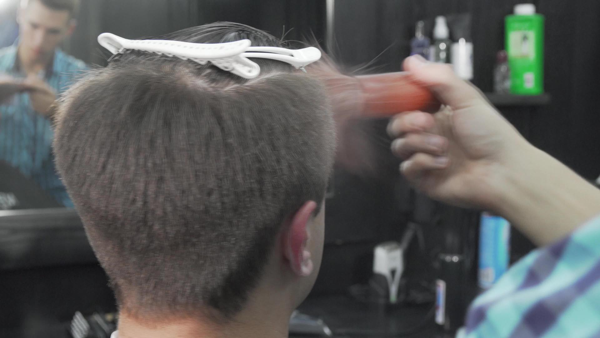 理发师给客户理发后梳理了他的头发视频的预览图