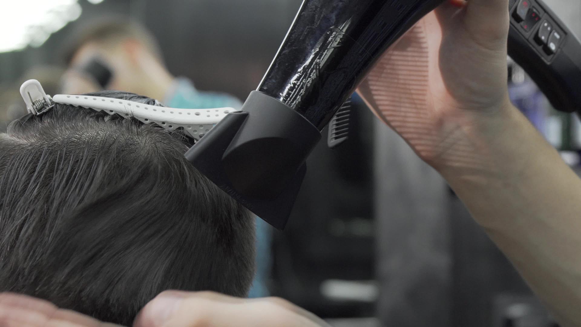 理发师使用吹风机和客户发型视频的预览图