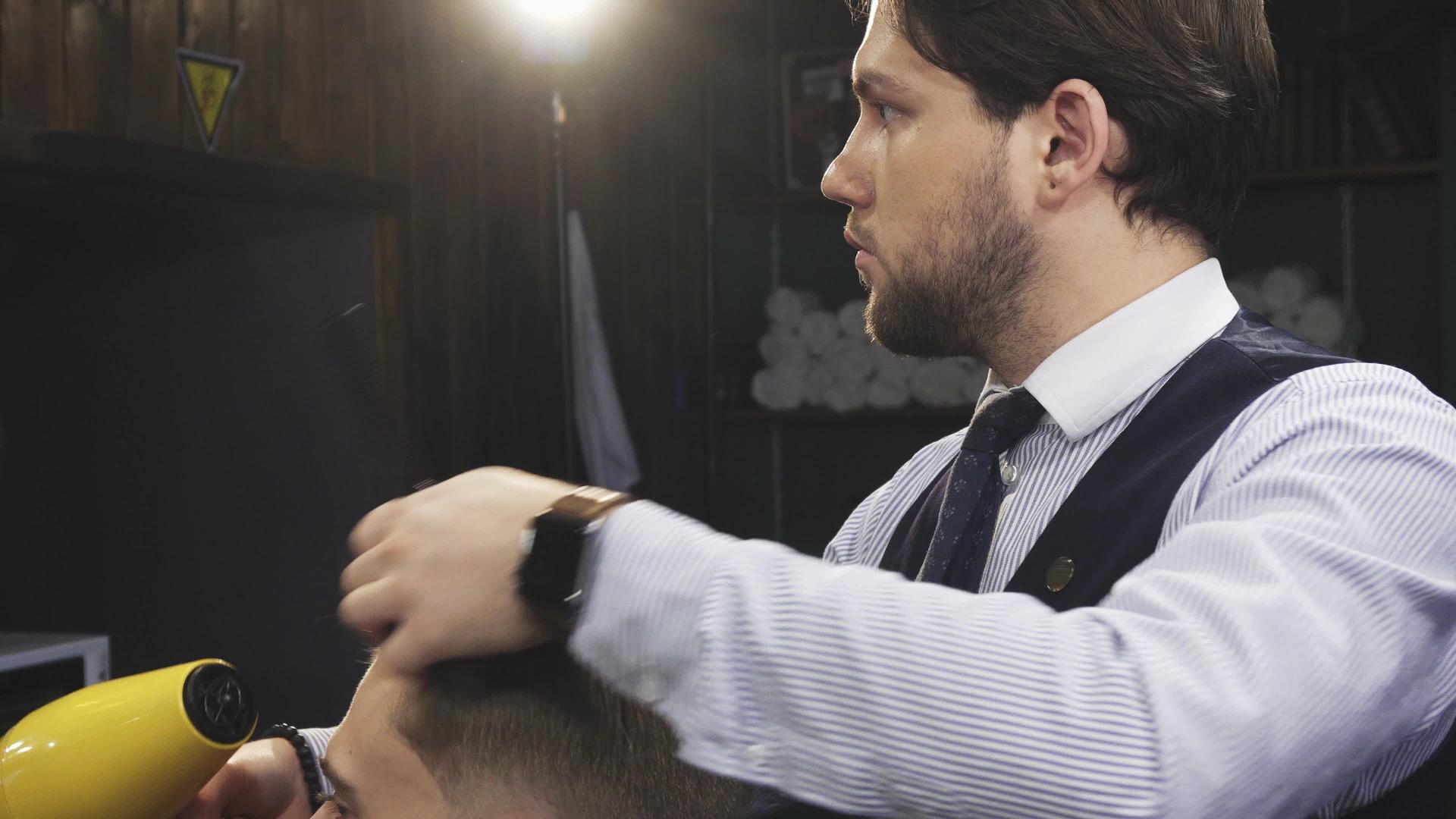 专业理发师吹干客户的头发视频的预览图