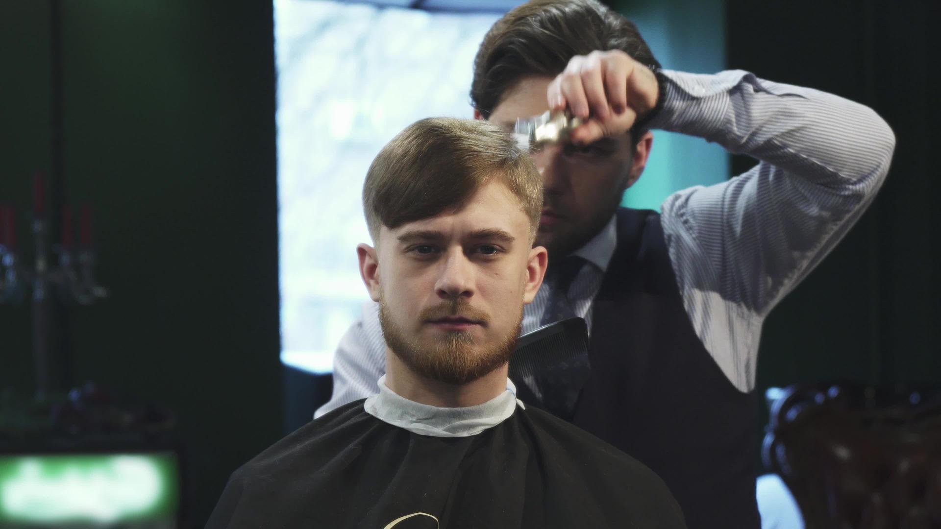 英俊的年轻人在理发店理发视频的预览图