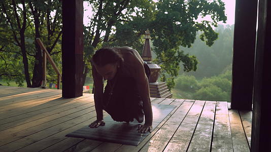 一个男人在木制平台上练习瑜伽视频的预览图