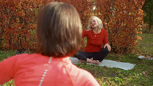 在秋季公园的户外瑜伽训练中冥想瑜伽的女性放松视频的预览图