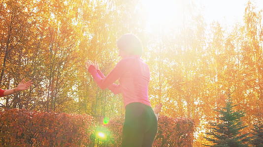 瑜伽女性在户外锻炼时练习体式健身女性在阳光下锻炼视频的预览图