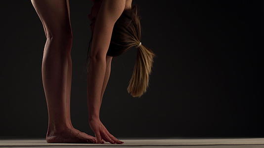 女孩练习瑜伽伸展手臂和腿触摸脚和跑步视频的预览图