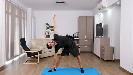 这个运动员在他的客厅里做了不同的瑜伽姿势视频的预览图