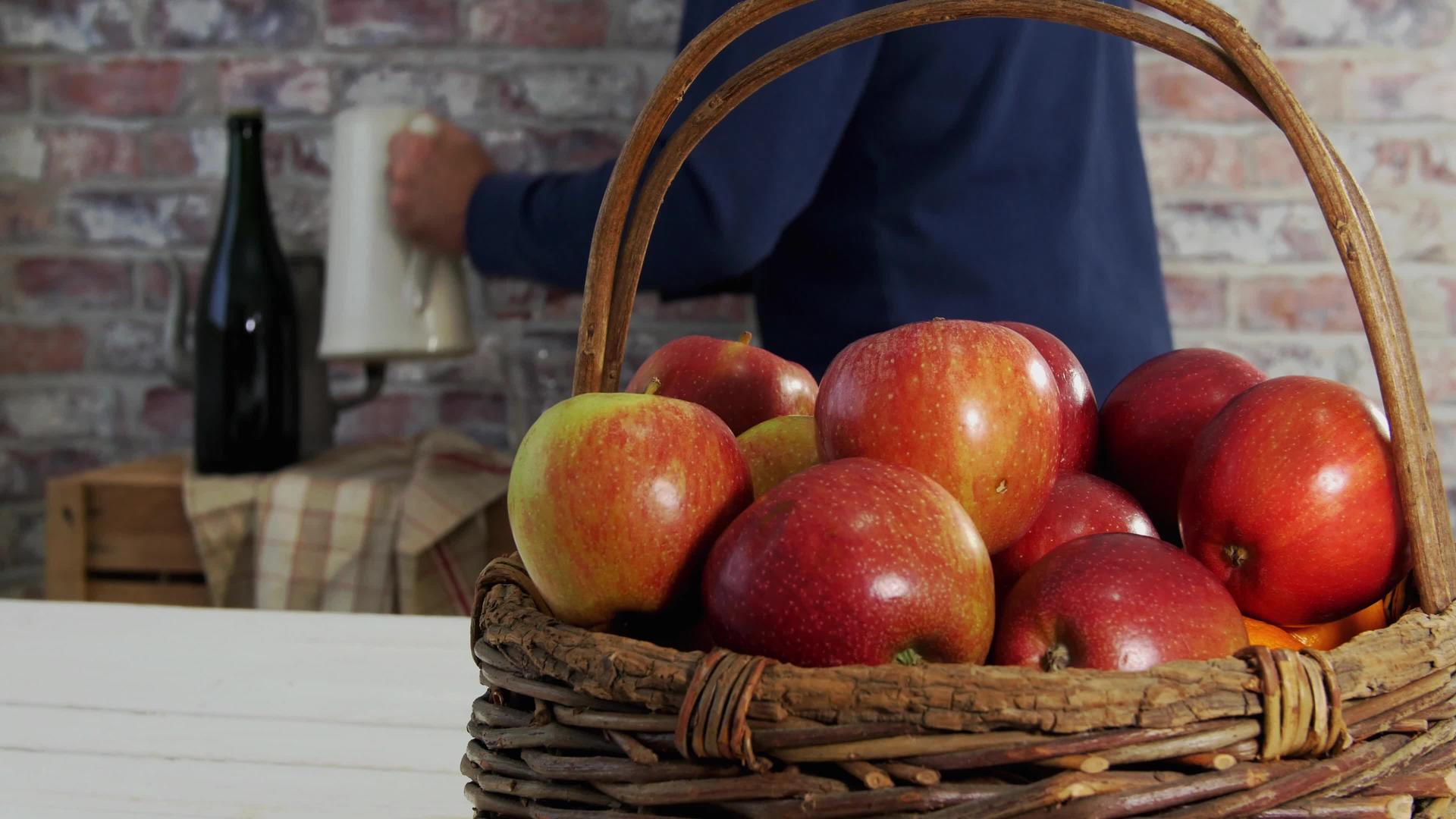 人们倒一杯普通的苹果汁在表面倒一篮苹果汁视频的预览图