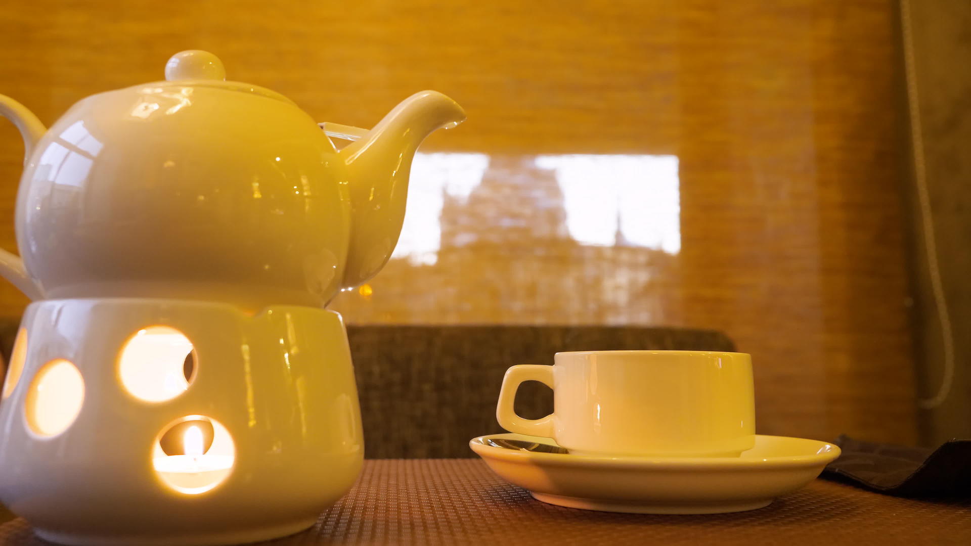 在桌子上的茶杯里烧蜡烛和热茶视频的预览图