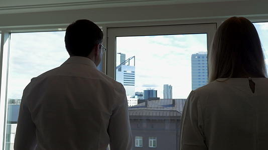 两个商人去了办公室的窗户视频的预览图