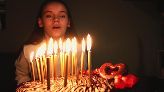 可爱的女孩在生日蛋糕上吹蜡烛视频的预览图