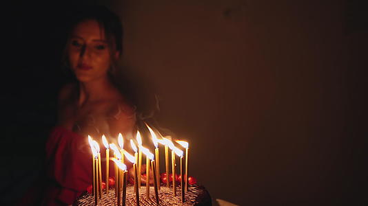 女孩在巧克力蛋糕上跳舞点上蜡烛庆祝生日视频的预览图