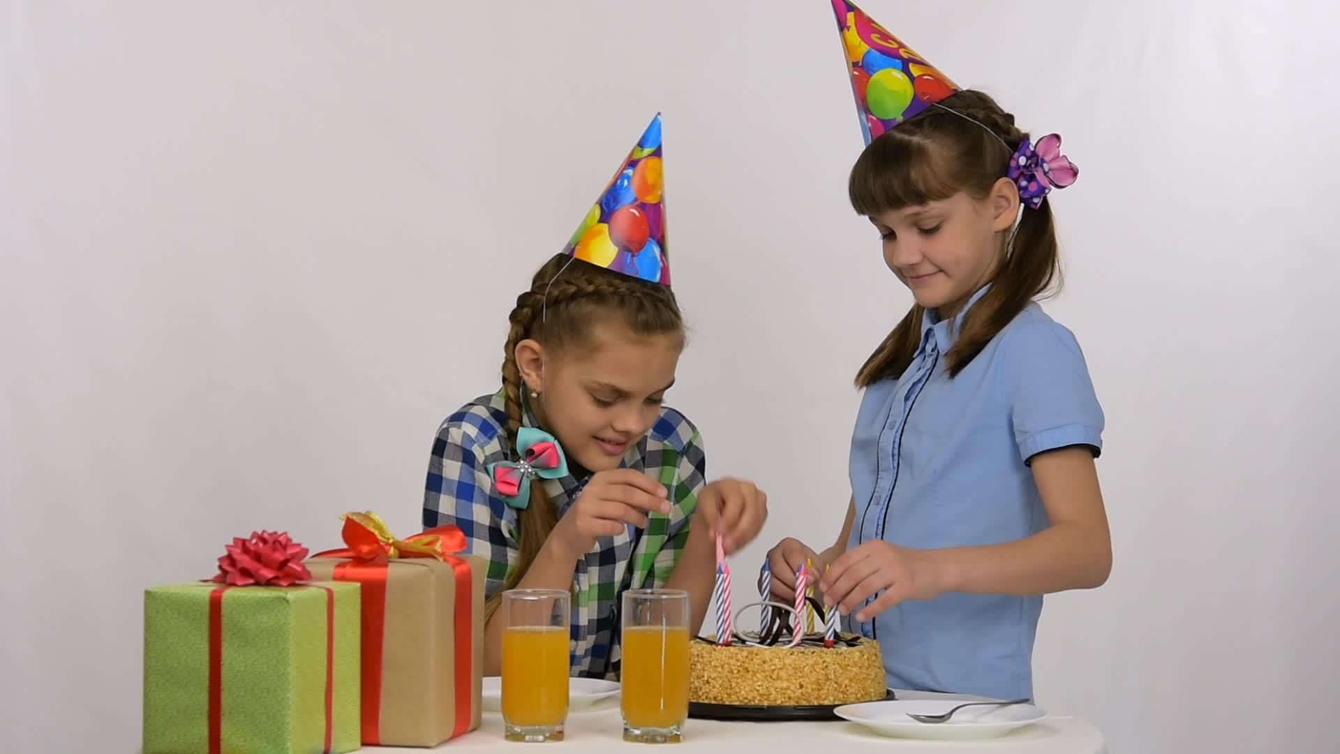 两个女孩把蜡烛放在生日蛋糕里视频的预览图