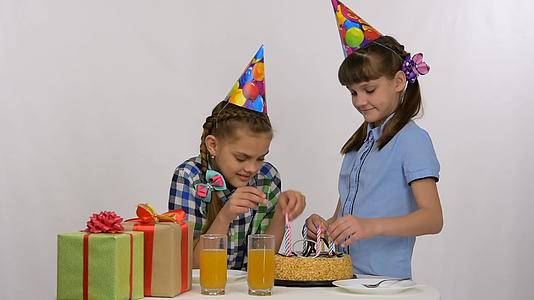 两个女孩把蜡烛放在生日蛋糕里视频的预览图