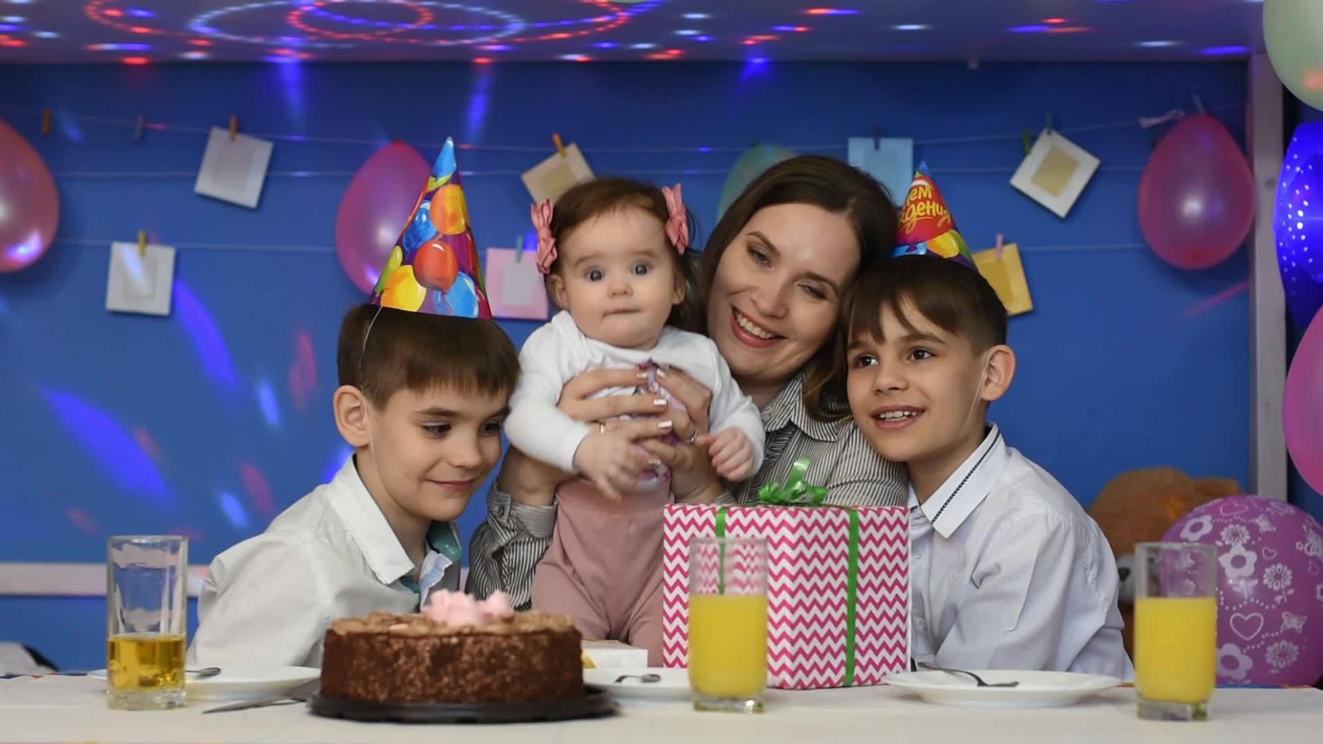 快乐的家庭母亲的女儿和两个男孩在家庭生日聚会上看着这个视频的预览图