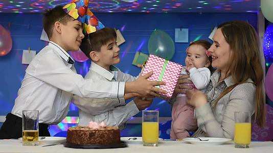 两个男孩祝贺母亲和孩子的生日并赠送礼物视频的预览图