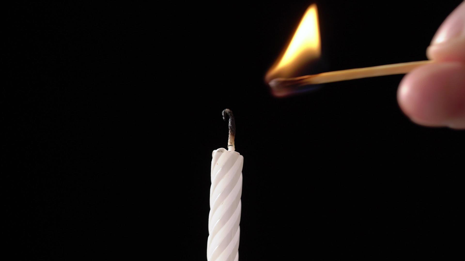 在庆祝生日蛋糕时用黑色背景点燃蜡烛视频的预览图