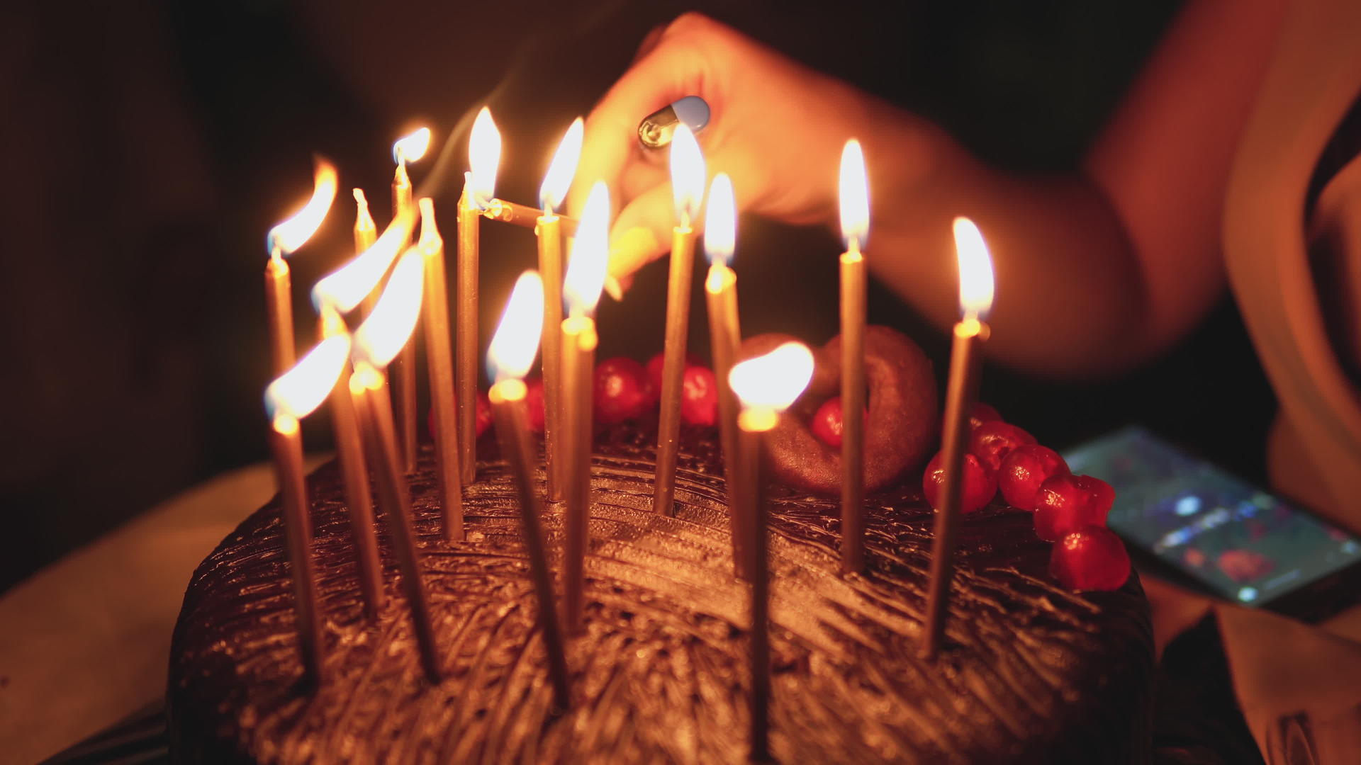 女人在巧克力蛋糕上点燃生日蜡烛视频的预览图