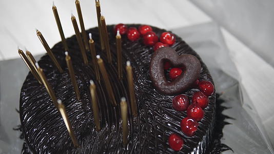 巧克力生日蛋糕在节日餐桌上有蜡烛视频的预览图