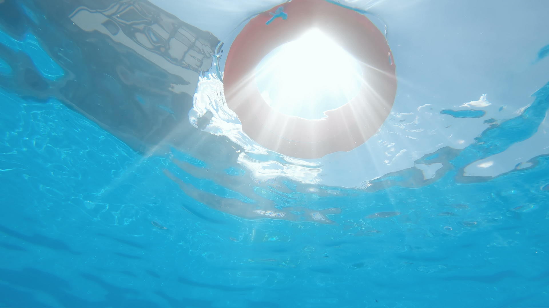漂浮在游泳池里的生命浮标阳光慢慢照耀水下风景视频的预览图