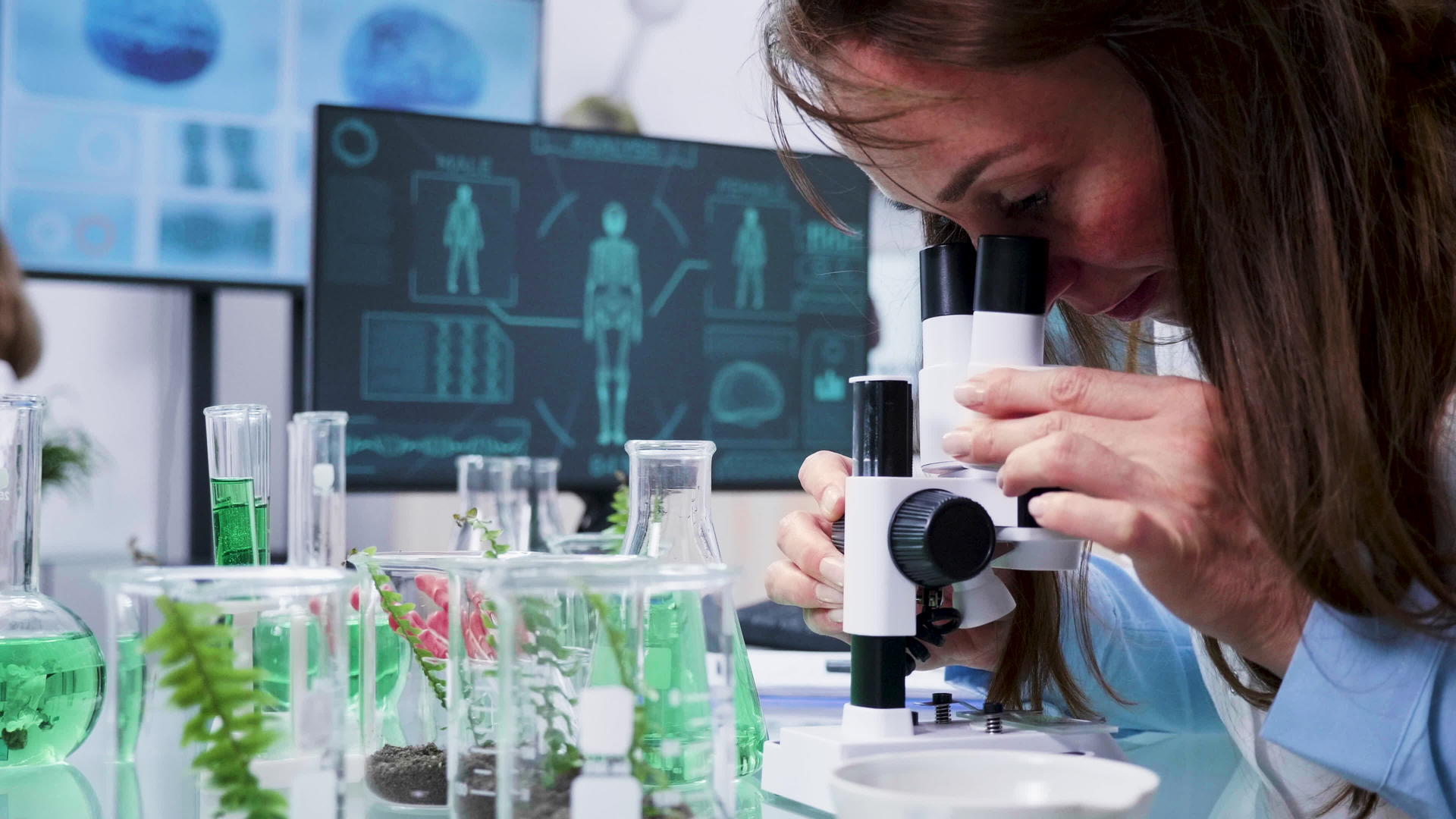 女性生物学家对显微镜的近距离镜头视频的预览图