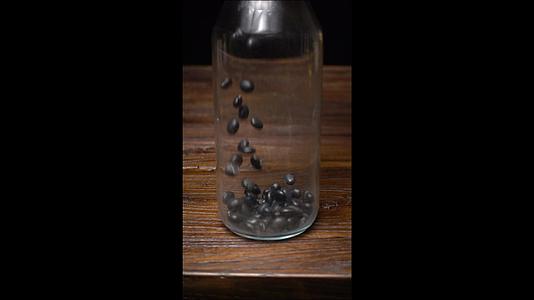 竖屏升格黑豆玻璃瓶中下落视频的预览图