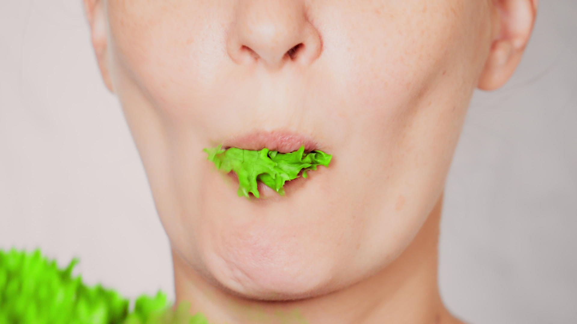 面对年轻女性吃蔬菜叶子视频的预览图