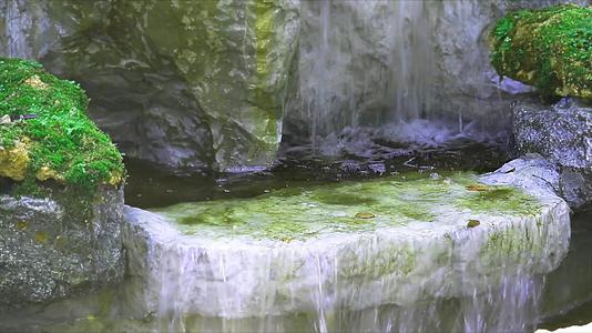 瀑布和绿苔藓漂浮在空中的喷水岩石上视频的预览图