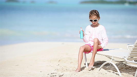 可爱的小可爱女孩坐在热带海滩上视频的预览图