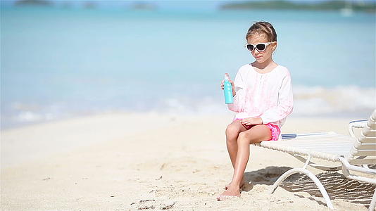 可爱的小可爱女孩坐在热带海滩上视频的预览图