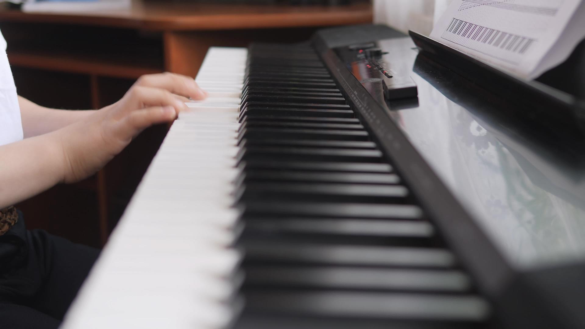 电子钢琴手指按下钢琴键音乐课手指按下乐器的侧面孩子视频的预览图